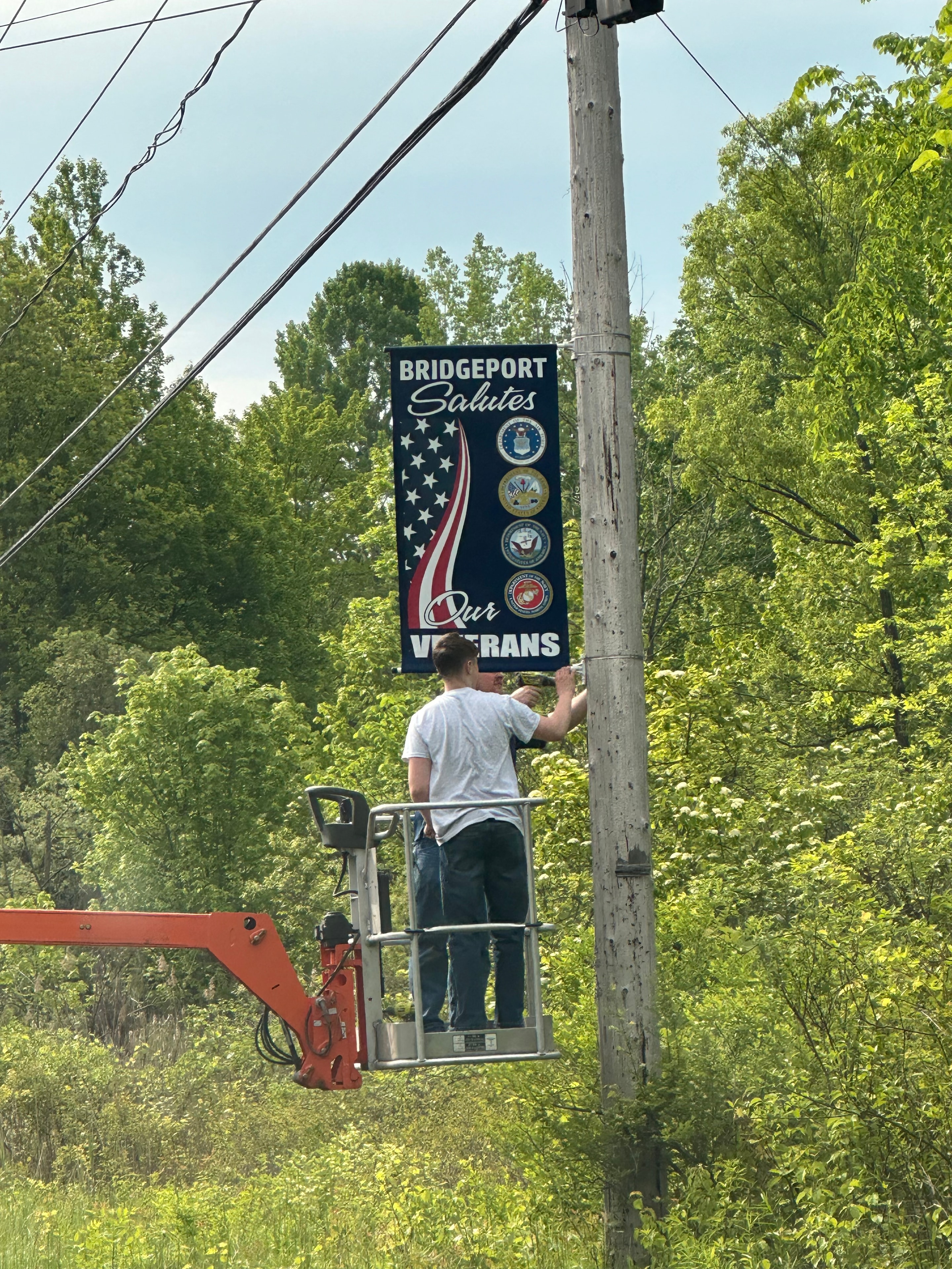 Bridgeport Salutes Our Veterans banner being installed on a telephone pole